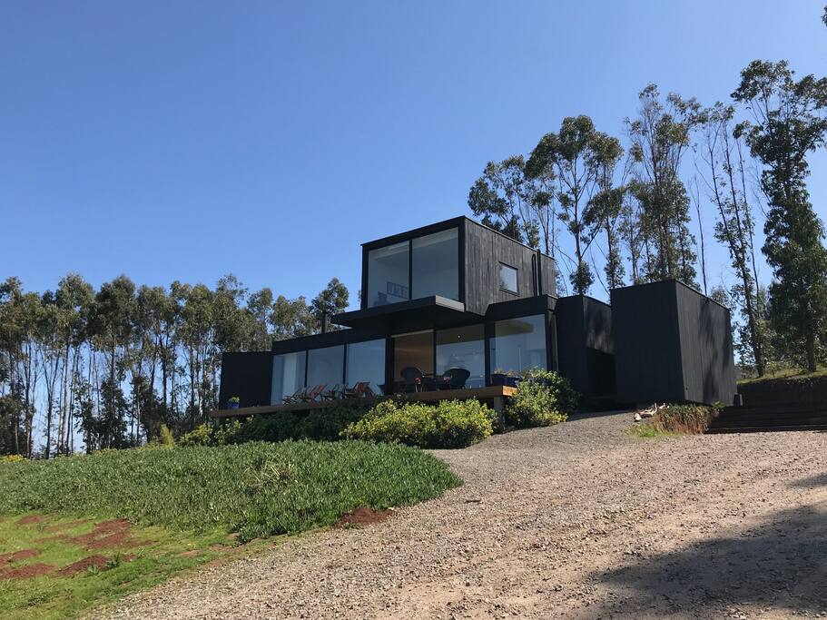 Fachada de la casa rodeada de naturaleza con un sitio de 5000mts2