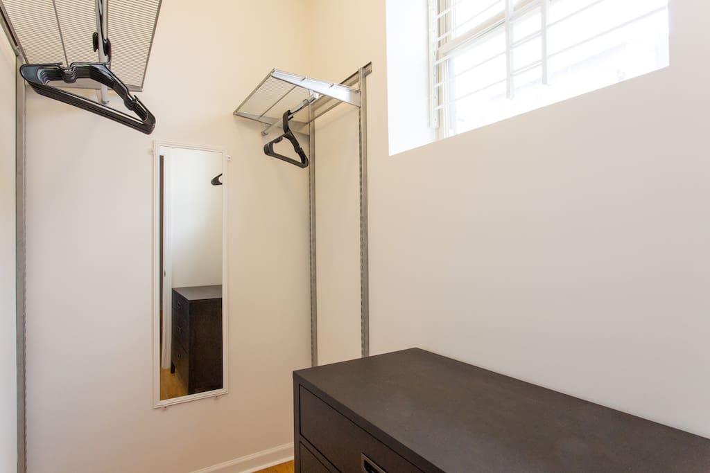 Walk-in closet with dresser and shelving units. Not pictured is another space on the left for hanging clothes.