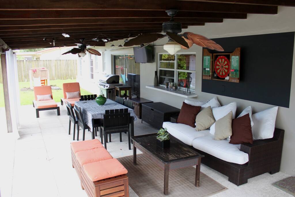 Full view of patio including dartboard and yard space with bocce, croquet.