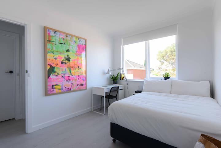 Grande chambre avec lit double, bureau et rangement