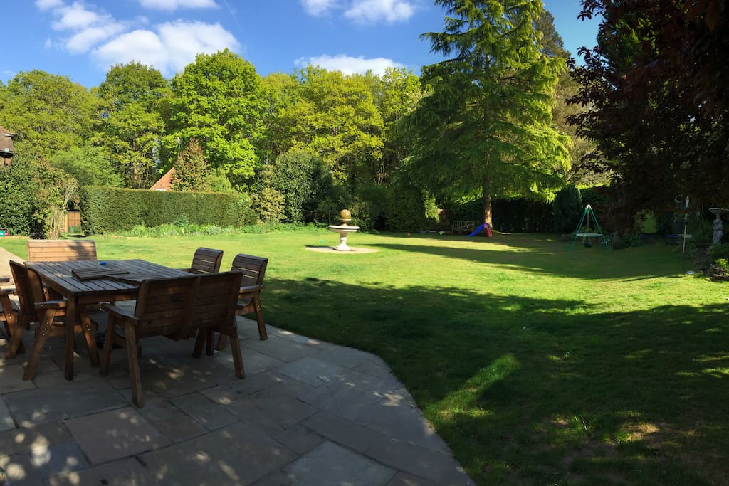 The house is surrounded by an acre of garden with a large table for eating.