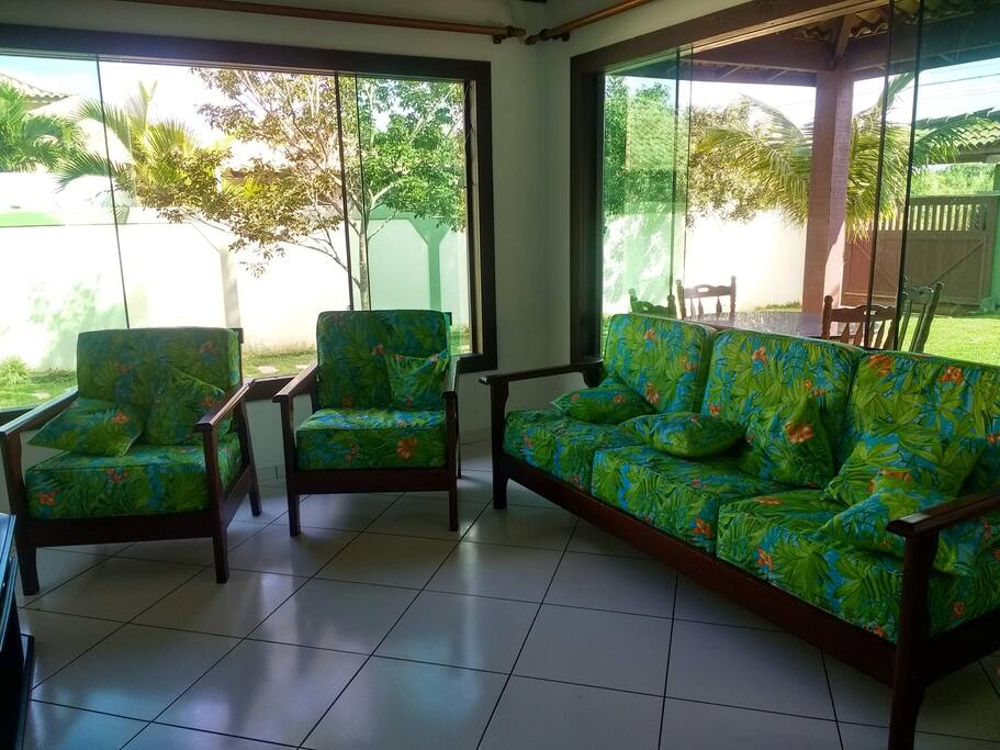 Sala de estar com varanda coberta atrás.