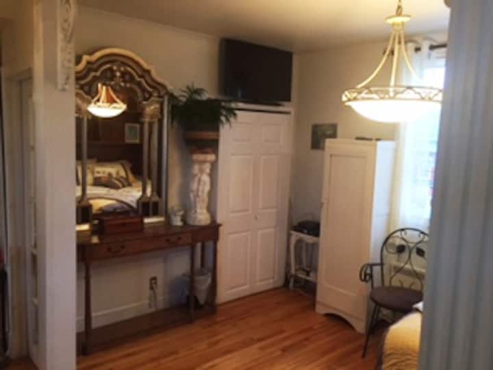 Суета во спалната соба, плакар за машина за перење/сушење алишта, телевизор и гардероба.