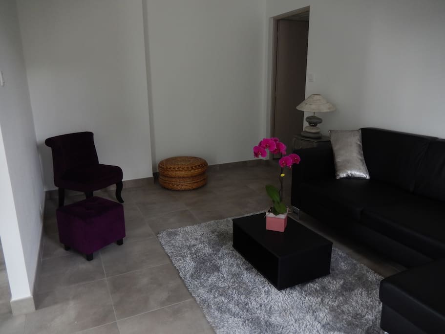 petit coin salon cosy avec télévision, canapé et fauteuil