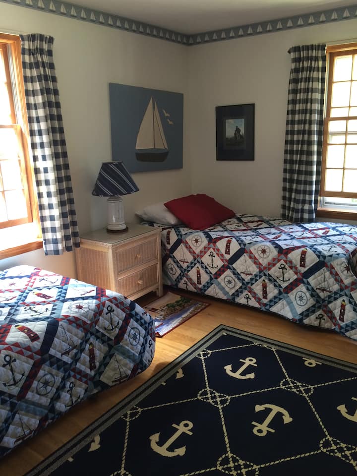 Dva odvojena kreveta u spavaćoj sobi s nautičkom tematikom
