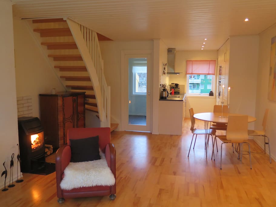 Livingroom with fireplace, dining area and kitchen in the background