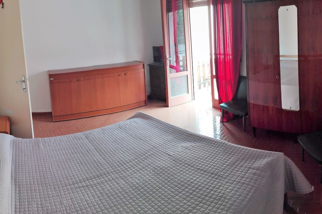 Camera da letto con piccolo balcone.