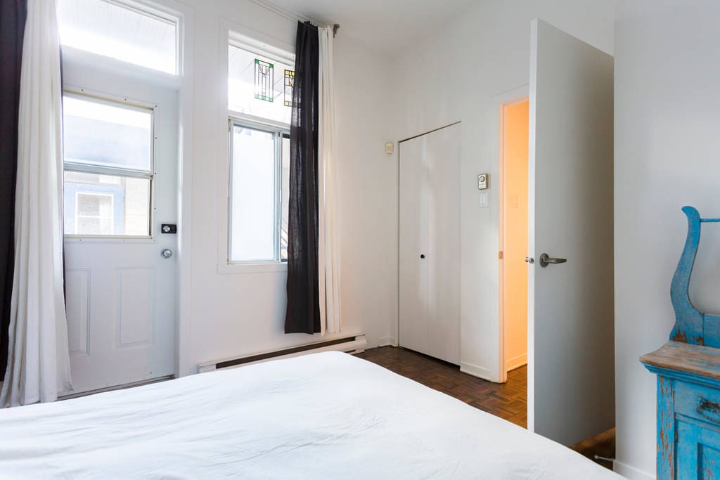 The bedroom has access to a small side balcony overlooking a courtyard