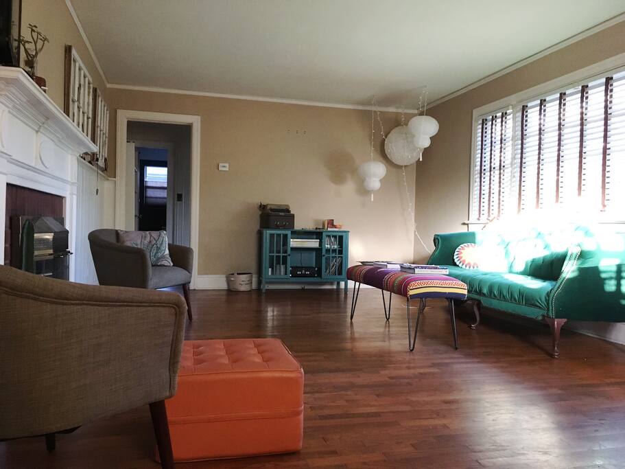 a sunny living area with a vintage couch and plenty of interesting reads