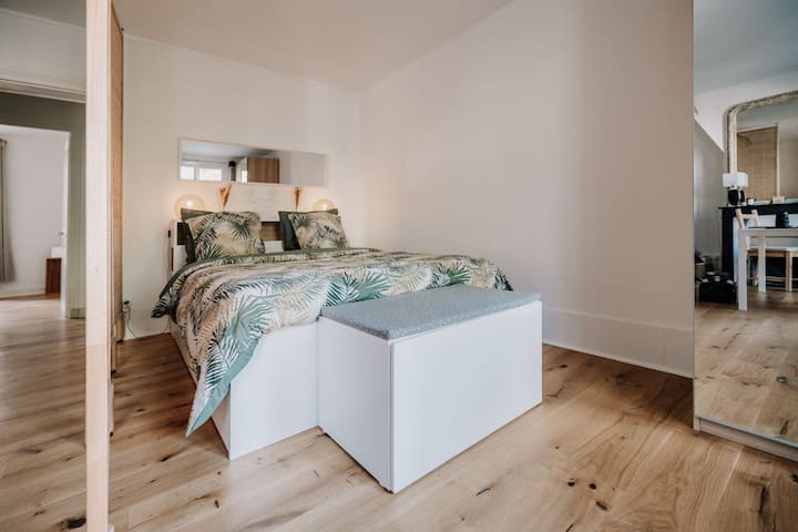 Habitación con armario, perchas y espejo de pie.