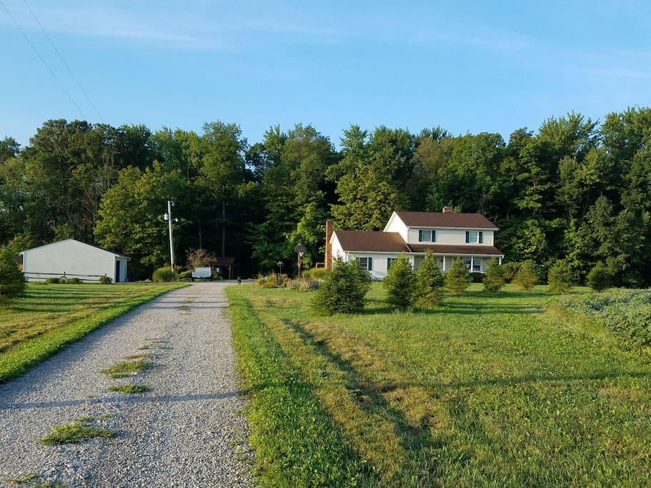 Our home is set back from the road in front of woods and surrounded by fields.