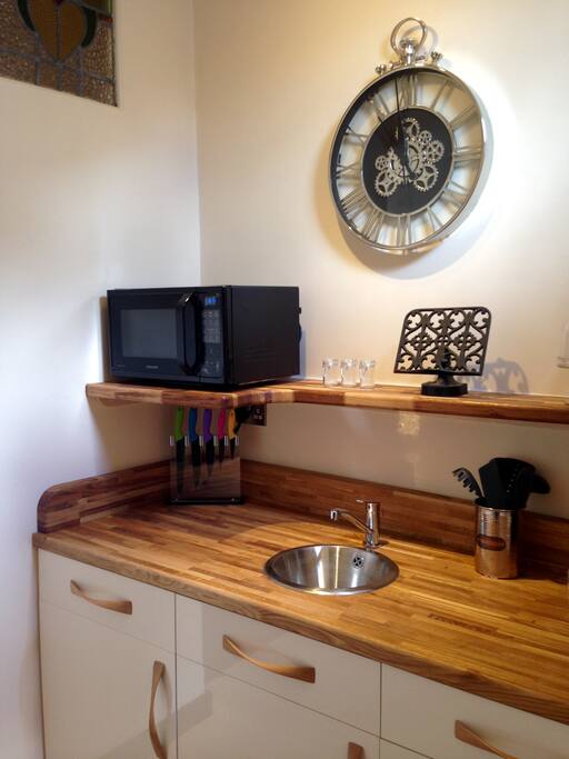 Compact but beautifully appointed kitchen adorned with a magnificent clock.