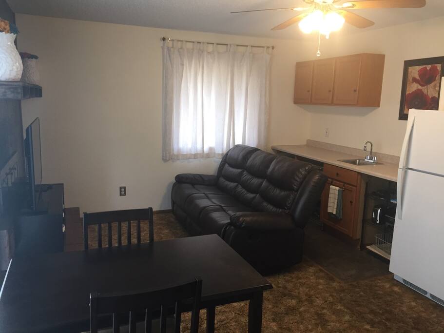 Full couch and kitchen area. The couch is able to recline on both ends.