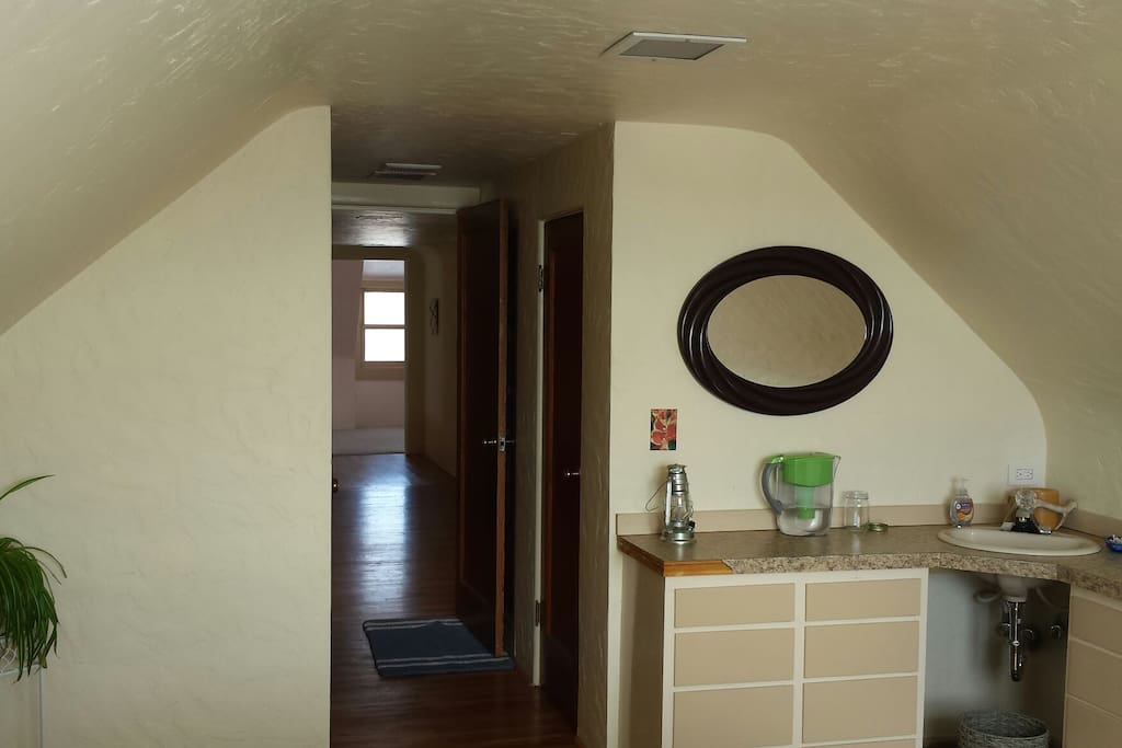 Bedroom with queen bed with bath looking through common area to private bedroom with double bed