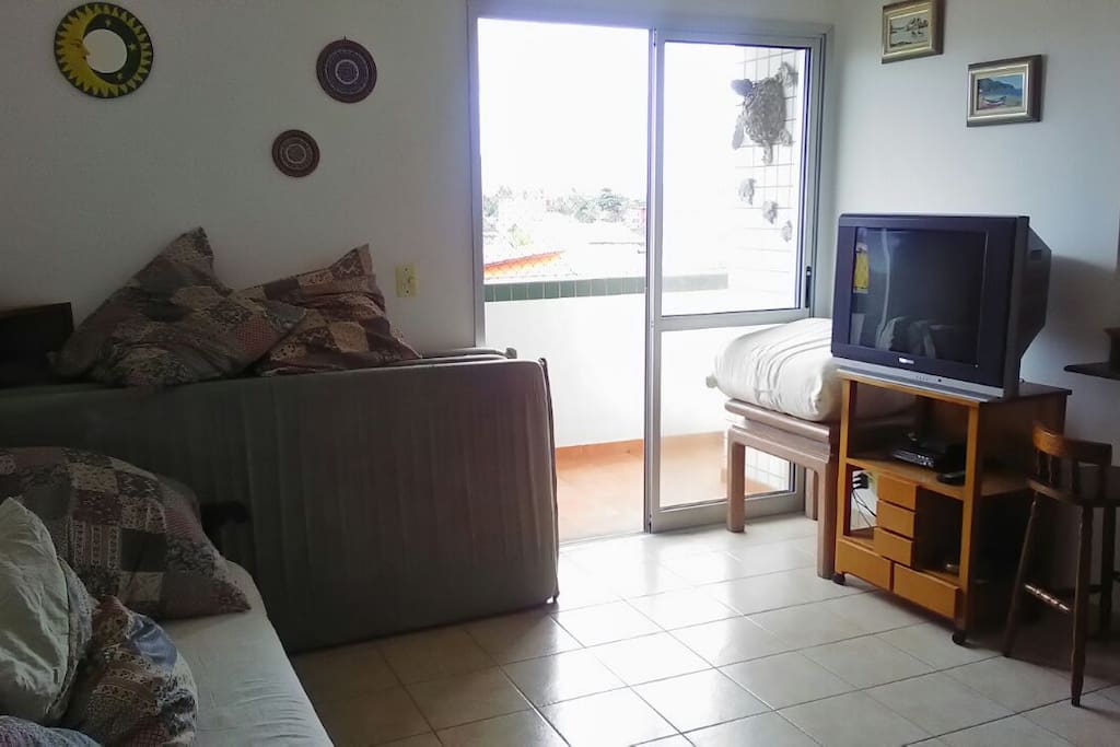 Sala com colchões, televisão e várias almofadas.