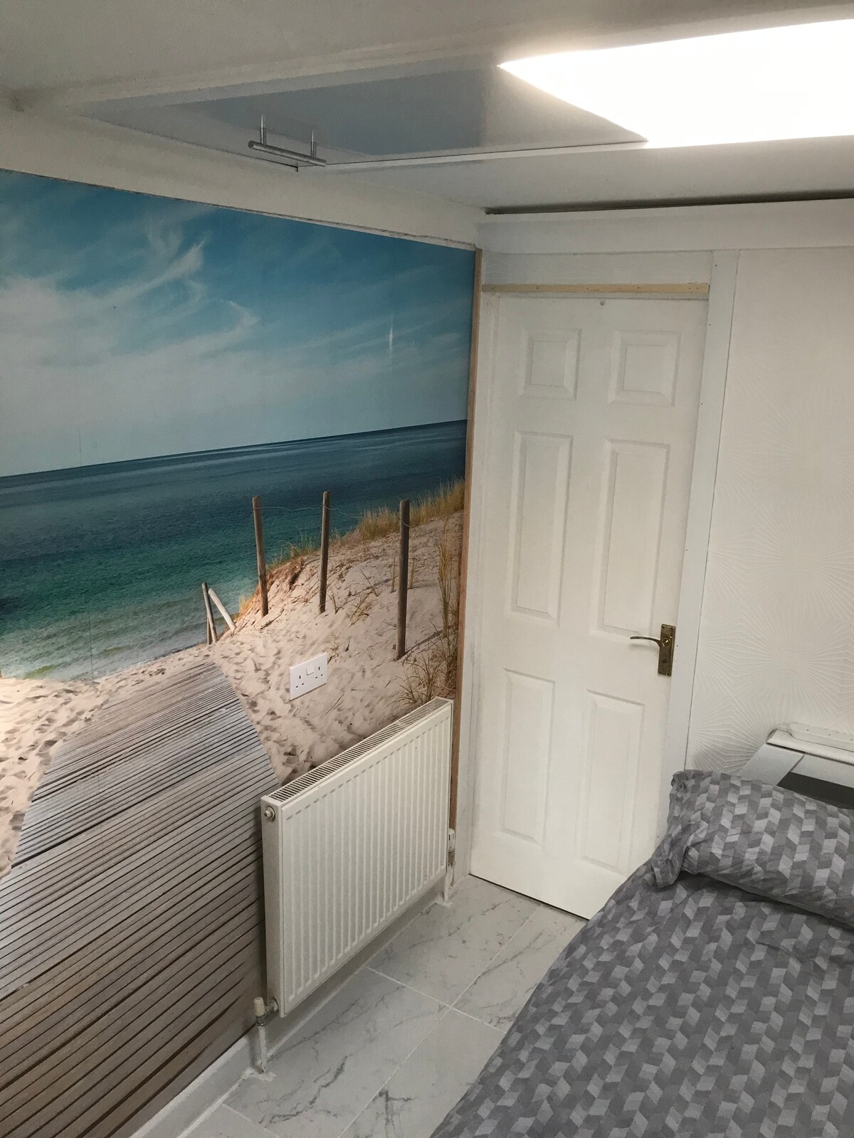 Спална соба со бања во апартман со убав мурал на плажа