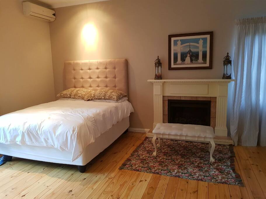 The Main Bedroom with en-suite, cosy fireplace and large mirrored cupboards