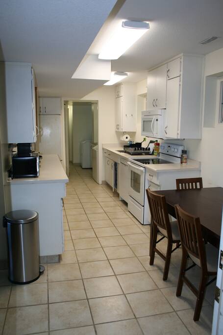 Galley kitchen is fully stocked with plates, cups, pots, pans, small appliances, etc.