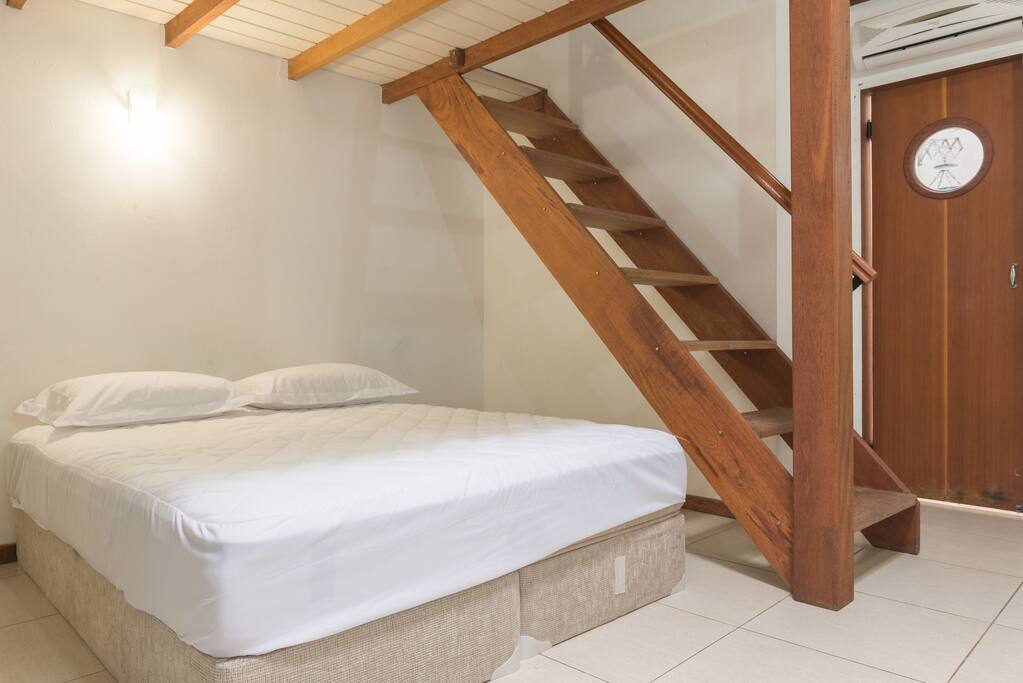 Escada para área superior e porta de uma pequena área de serviço.
Stair to the top loft area and door of the small service area.
