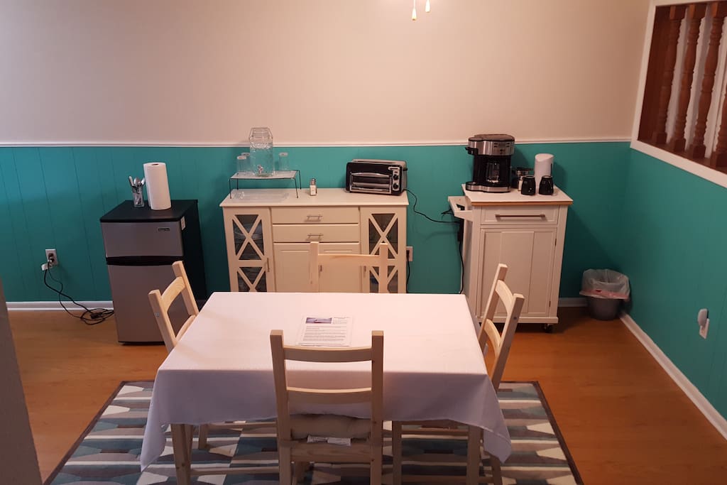 Dining area contains a coffee/tea station, a sidebar where a continental breakfast is served, mini fridge for guest use, and a water station.