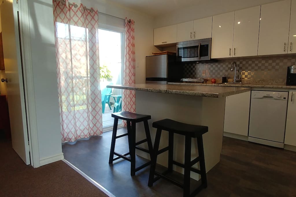 Kitchen with Island that serves as a dining table. Four bar stools available.