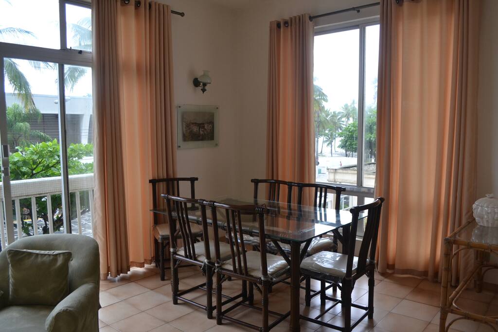 Sala de jantar integrada com janelões, bem iluminada