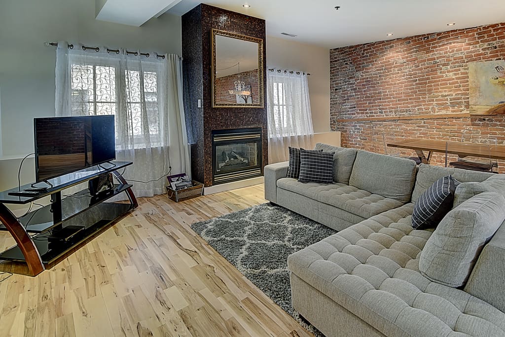 A comfortable living area with large TV, plush carpet and gas fireplace