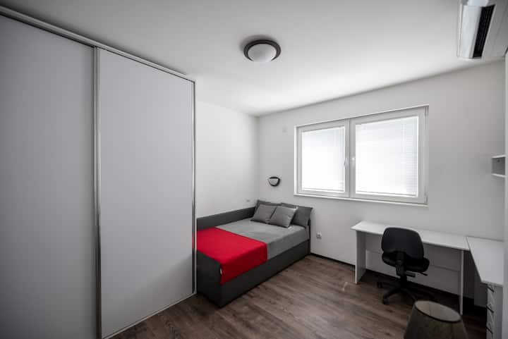 Posteľ v menšej spálni. Tiež je vybavený veľkým šatníkom a pracovným stolom