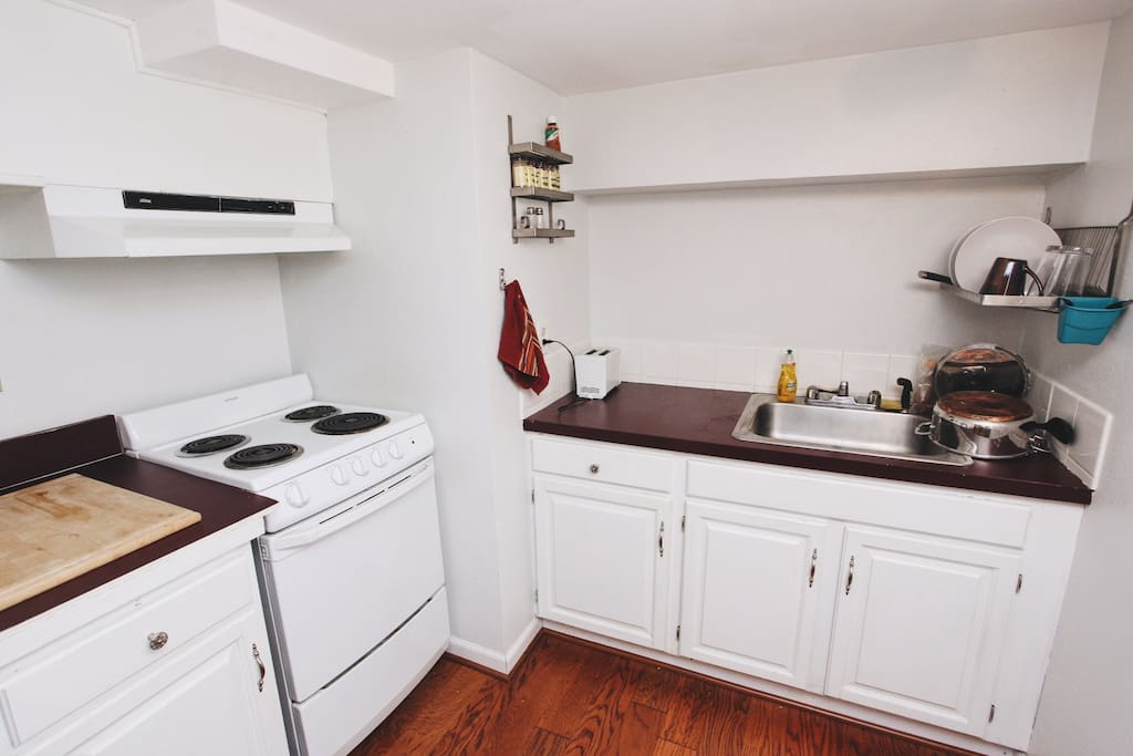 The kitchen is outfitted with a stove, oven, refrigerator, toaster, microwave, and French press.