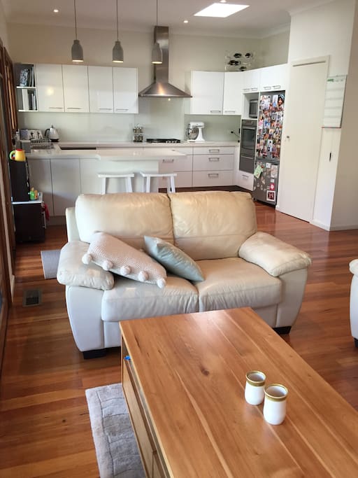 The kitchen opens out onto a TV area with comfy couches. There is a mini kitchen for kids to enjoy practising their cookery skills, and a small table and chairs.