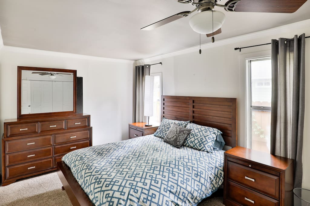 Spacious large bedroom with dresser and mirror.