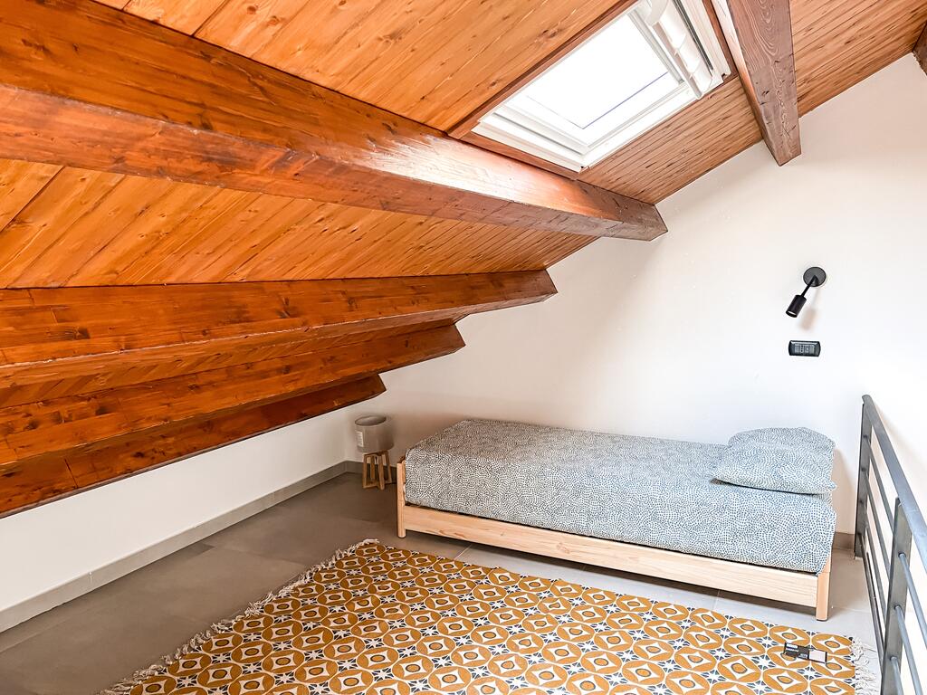 Bedroom 2 with two single beds, power outlets and lights near both beds and towel sets included.