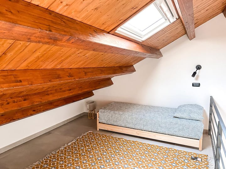 Bedroom 2 with two single beds, power outlets and lights near both beds and towel sets included.