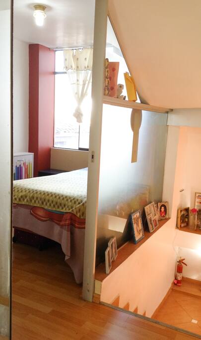Habitación 1 con ventanas amplias, cama de 1.5 plazas, ropero y estante