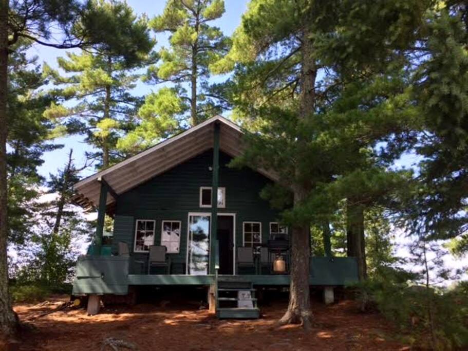 Front view of cabin, with deck chairs and propane grill shown