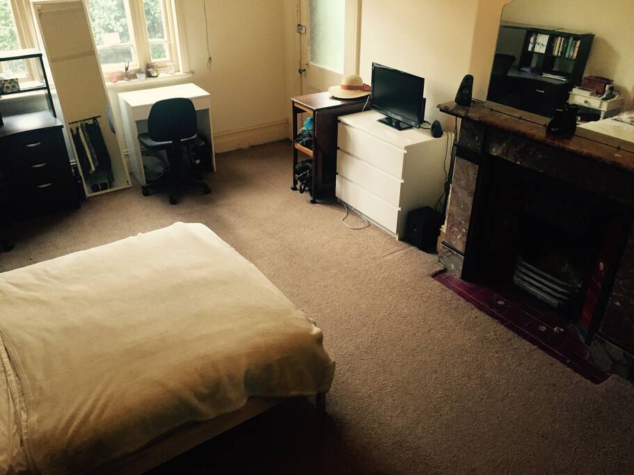 Spacious room with double bed, 1 large and 1 small desk, and storage space for clothes