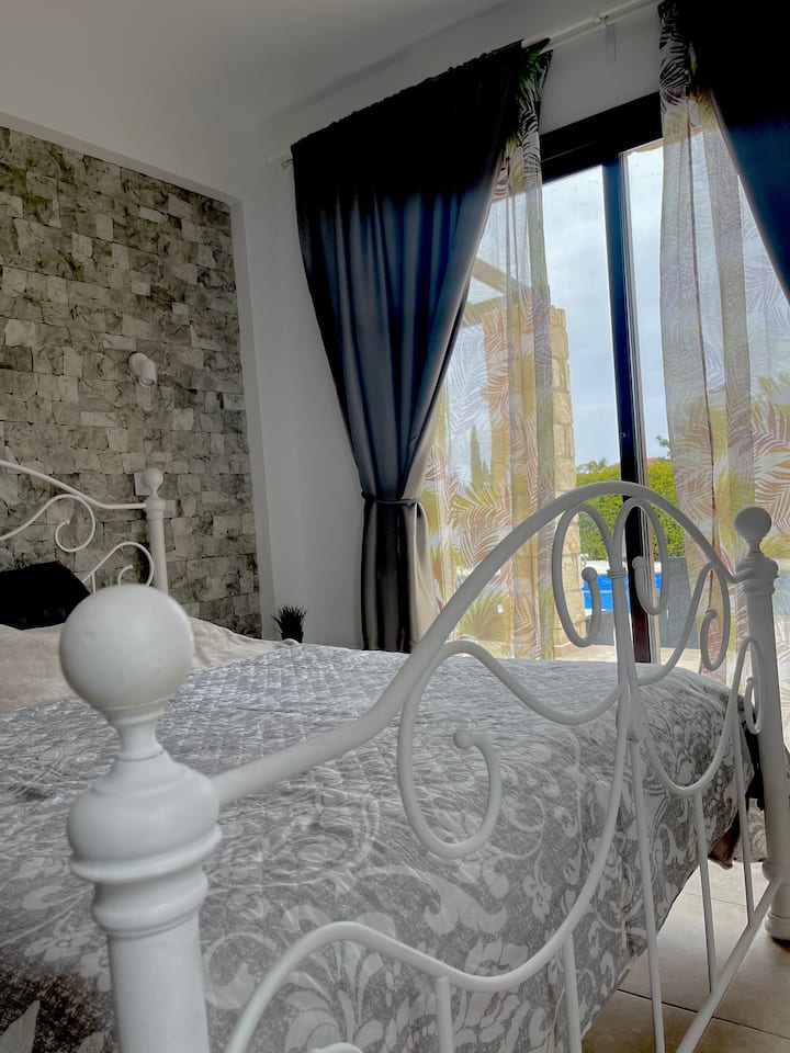 غرفة نوم في الطابق الأرضي. سرير مزدوج 150 × 190 سم. الخروج إلى حمام السباحة الخاص. 