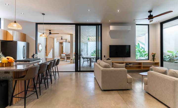 Müasir dekorasiya ilə bəzədilmiş və təbii işığa bürünmüş qonaq otağı açın.