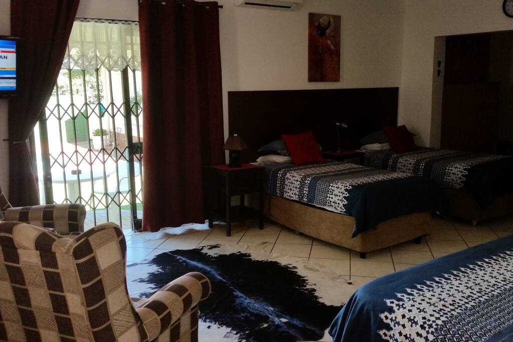 Double bed and two single beds. Sitting area. Door to garden