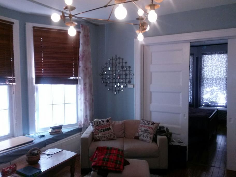 Spacious living room with couch and window seating. Television with Netlix and Hulu.