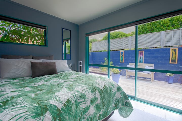 غرفة نوم بحجم كوين ترتدي ملابس الصيف تطل على السطح الخلفي في الطابق العلوي