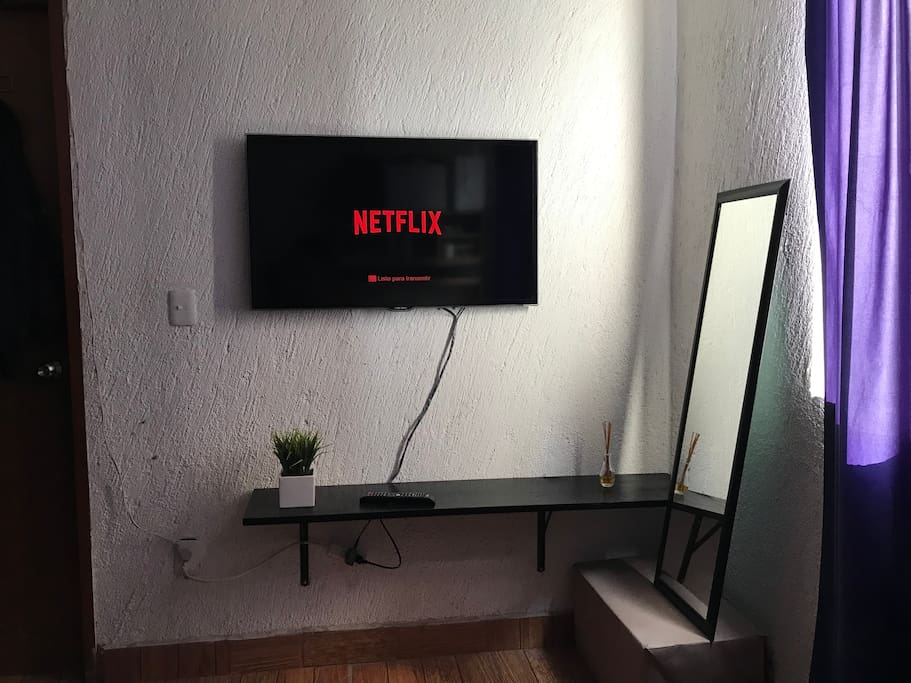 Televisor 43” smartv, con Netflix a su disposición. Bancas para sentarse, y espejo vertical.