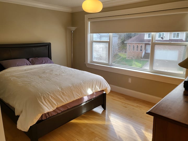 Dhoma e tretë e gjumit me krevat dopio "queen" dhe komodinë dhe grila të errëta. Pamje nga rruga.