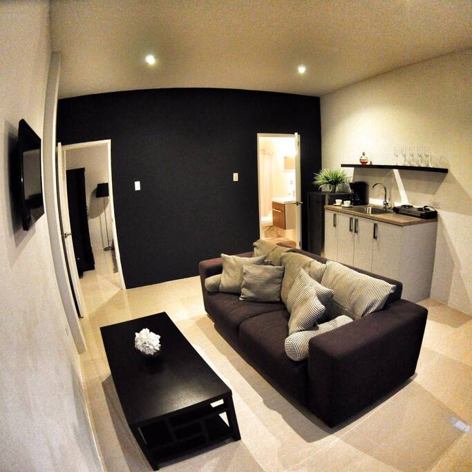 Open kitchen with stove , microwave and tall fridge .