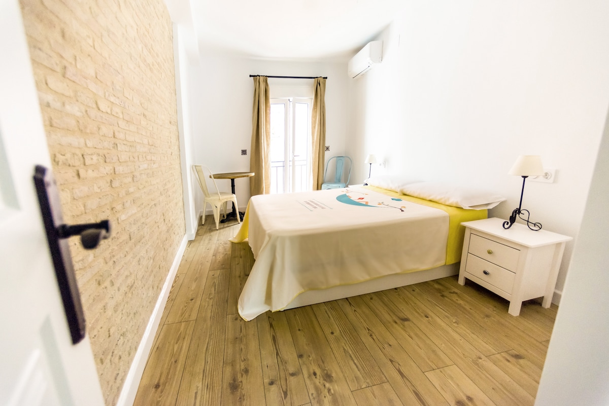 Dormitorio con una cama doble, armario grande con espejo en el interior y aire acondicionado