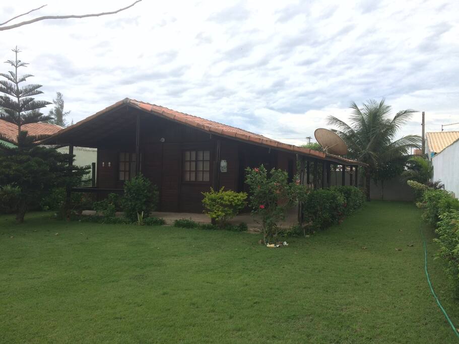Casa com varanda e amplo quintal representado em parte nesta foto.