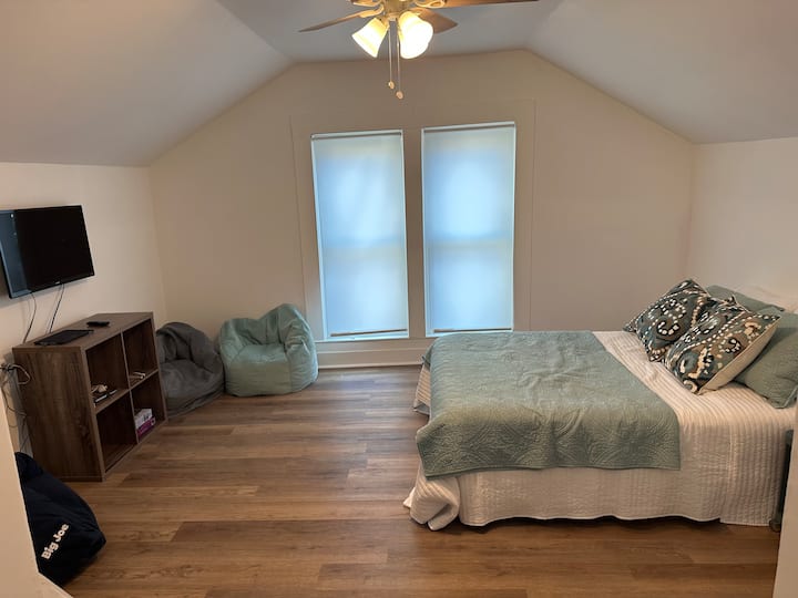 Posteľ v plnej veľkosti s TV a konzolou wii 