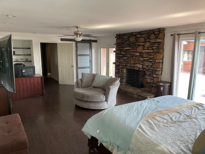 Master Bedroom with fireplace, office space, sitting area, and access to balcony. 