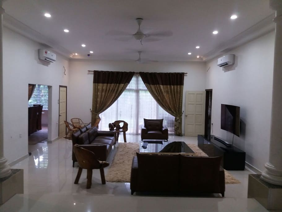 Living area with leather sofa and 65 inches WiFi Curved TV.