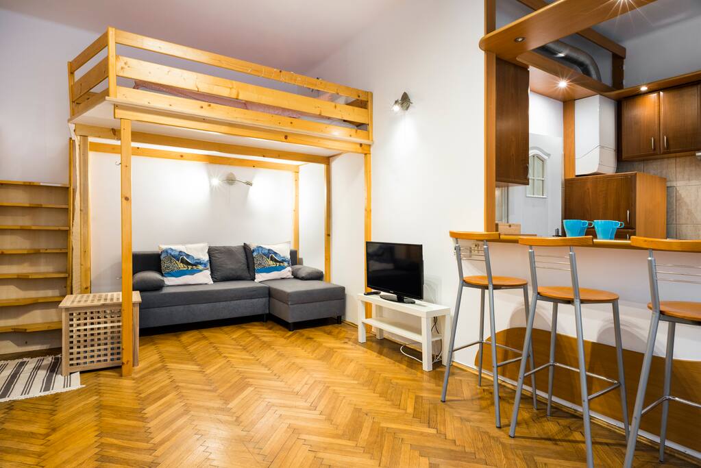 Cosy living room with sofa bed, armchair, wardrobe, TV and entresol bed